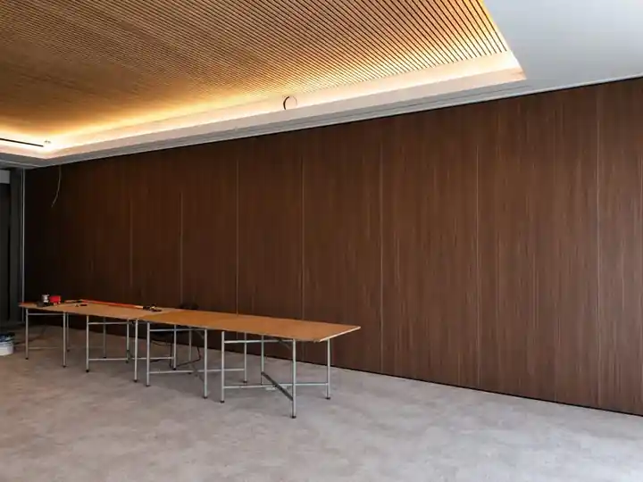 Pormenor dos painéis da parede móvel WINAB em melamina walnut sob teto em ripas de madeira