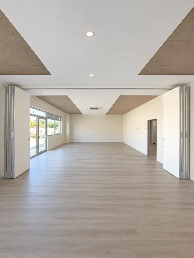 Paredes móveis de harmónio WINAB recolhidas, com as duas salas de aula unidas num só espaço na Almada International School