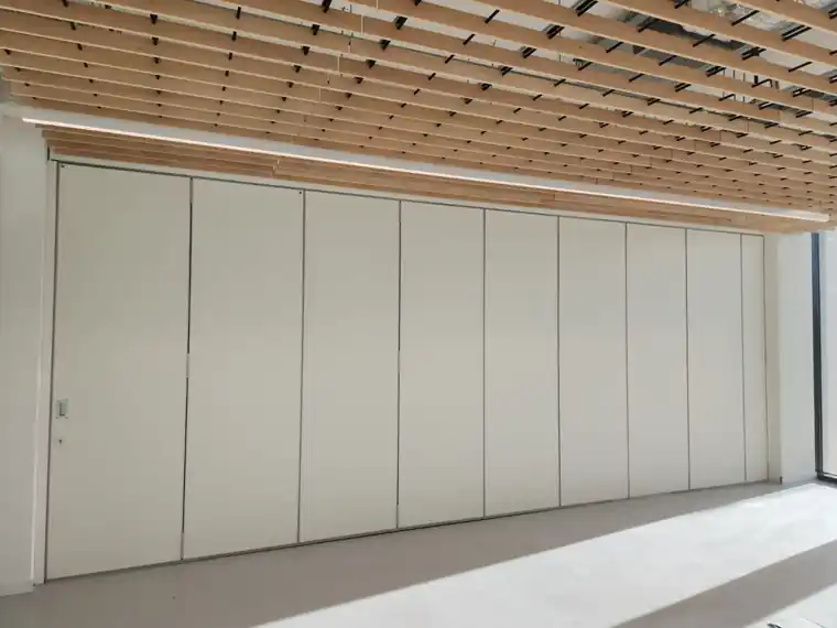 Parede móvel de harmónio WINAB fechada, com 10 metros e porta de passagem, na sala multiusos do Centro de Capacitação da STET, em Beja