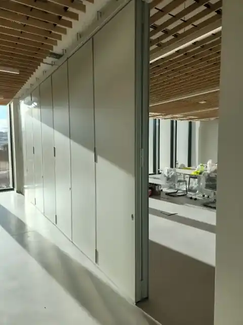 Parede móvel de harmónio WINAB com o pacote de painéis recolhido, sala multiusos do Centro de Capacitação STET em Beja
